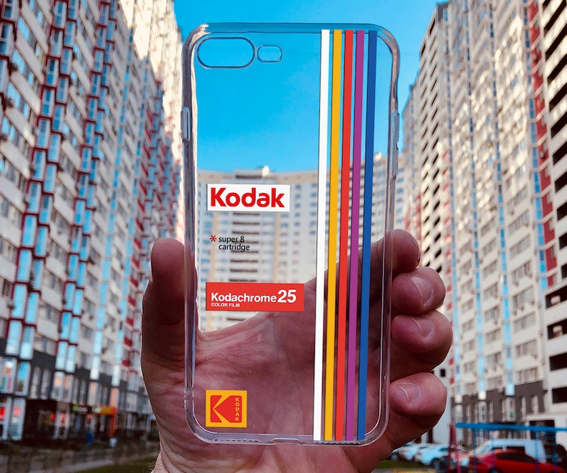 May include: A clear phone case with a colorful stripe design and a 25 film cartridge graphic. The case features the logo and the text "super 8 cartridge".
