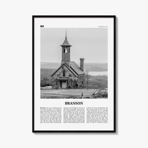 May include: A black and white framed print featuring a stone church with a steeple, set against a landscape. The text includes BS, MISSOURI USA, BRANSON, and a descriptive paragraph about Branson, Missouri, detailing its location and attractions.