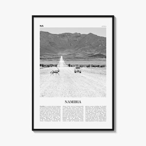 May include: A black and white framed wall art print featuring a landscape of Namibia. The image shows a dirt road leading toward mountains, with an oryx crossing the path and a vehicle in the distance. The text includes NA, AFRICA, and NAMIBIA.
