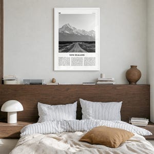 New Zealand Poster, black and white photo print in a white wood frame, hanging in a bedroom