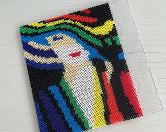 May include: A colorful abstract portrait made with perler beads. The portrait features a person with a white face, red lips, and blue hair. The background is black with colorful stripes.