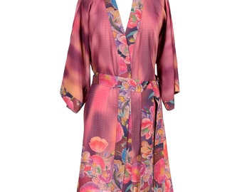 May include: A long, pink robe with a floral print. The robe has a tie belt and a V-neck.