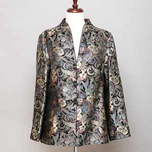 May include: A black, gold and blue patterned jacket with a mandarin collar and a V-neck. The jacket has a button closure and long sleeves.