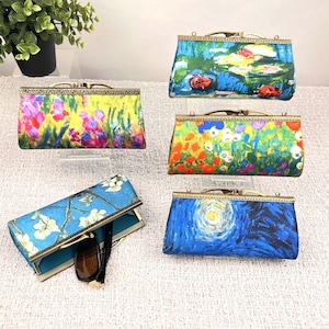 May include: Five decorative clutch purses with brass-colored frames. The purses feature colorful floral and landscape art prints, including a water lilies scene, a field of flowers, and a starry night design. One purse holds a pair of sunglasses.