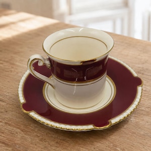 Xícara de café expresso com pires, modelo Ambassador Ware, da Soho Pottery, em tons de marrom e dourado, estilo vintage dos anos 1930.