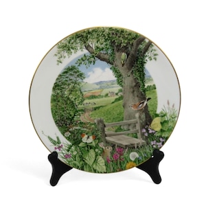 May include: A white ceramic mug with a black handle and the text "But First, Coffee" in a black, handwritten-style font. The mug is on a white surface.