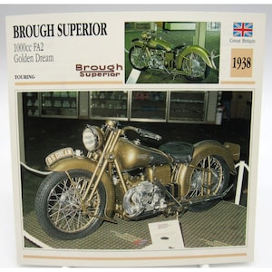 May include: A vintage Brough Superior motorcycle, the "Golden Dream" model, from 1938. The motorcycle is a gold color with a black seat and tires. The image includes the text "Brough Superior" and "1000cc FA2".