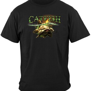 May include: Black t-shirt with a graphic of a catfish swimming in water with the word "CATFISH" above it.