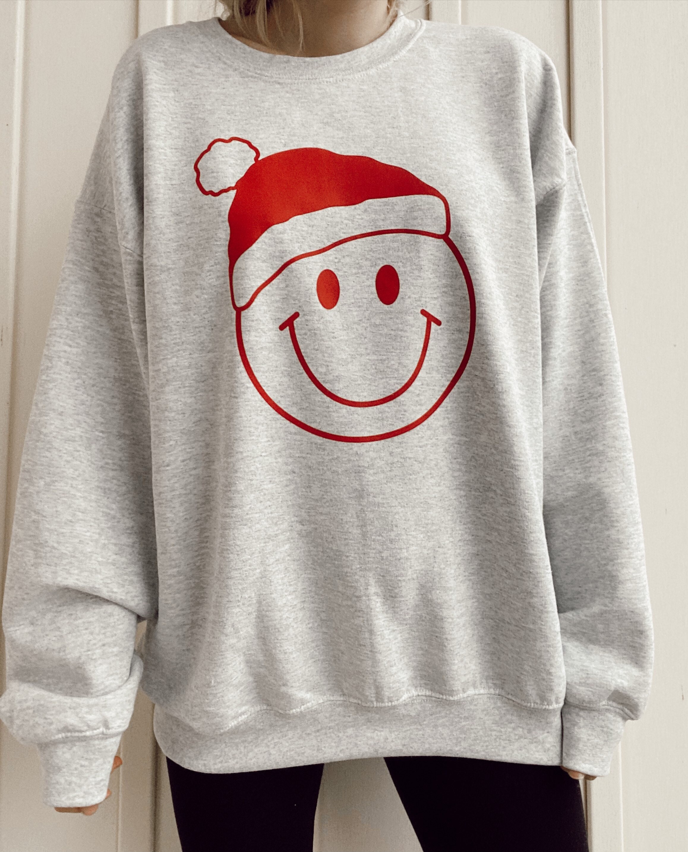 Discover Smiley Face Christmas Sweatshirt / Light Grey / Santa Hat