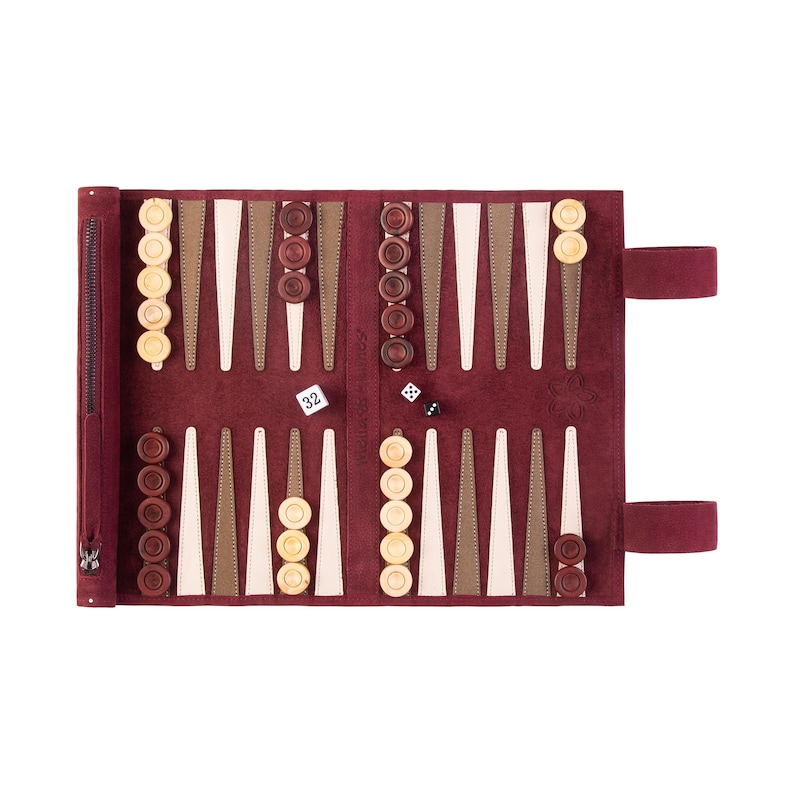 May include: A red leather backgammon set with wooden playing pieces. The set is open and ready to play. The dice are visible on the board.