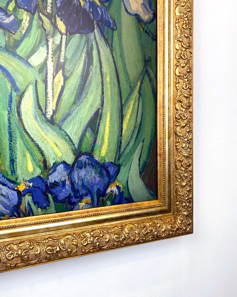 Puede incluir: Impresi&oacute;n enmarcada de una pintura con lirios. La obra presenta lirios azules y morados con hojas verdes, sobre un fondo de pinceladas verdes y amarillas. La pintura est&aacute; encerrada en un marco dorado y ornamentado.
