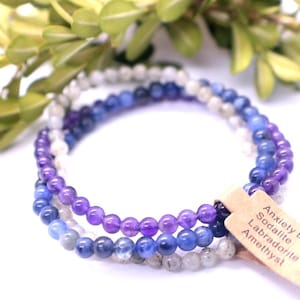 May include: A layered bracelet made with amethyst, sodalite, labradorite, and moonstone beads. The bracelet has a tag that reads "Anxiety Bundle, Sodalite, Labradorite, Amethyst".