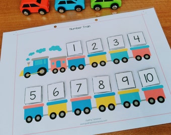 May include: A printable number train activity for kids. The train is made of blue, yellow, and red cars. The numbers 1 through 10 are on the cars. The text "Number Train" is at the top of the page.