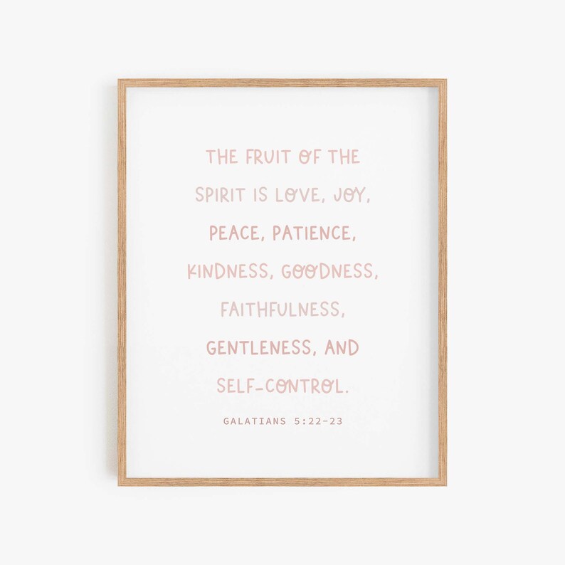 May include: A framed print with a white background and pink text. The text reads "The fruit of the spirit is love, joy, peace, patience, kindness, goodness, faithfulness, gentleness, and self-control. Galatians 5:22-23".