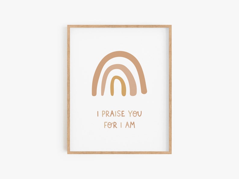 May include: A framed print with a rainbow in shades of brown and yellow. The text "I praise you for I am" is below the rainbow.