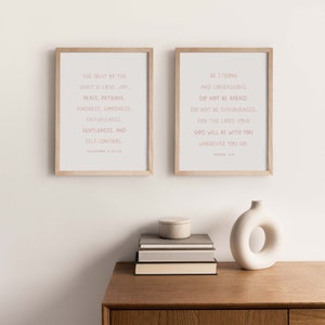 May include: Two framed prints with inspirational quotes. The left print features a quote from Galatians 5:22-23 about the fruit of the spirit. The right print features a quote from Joshua 1:9 about being strong and courageous.