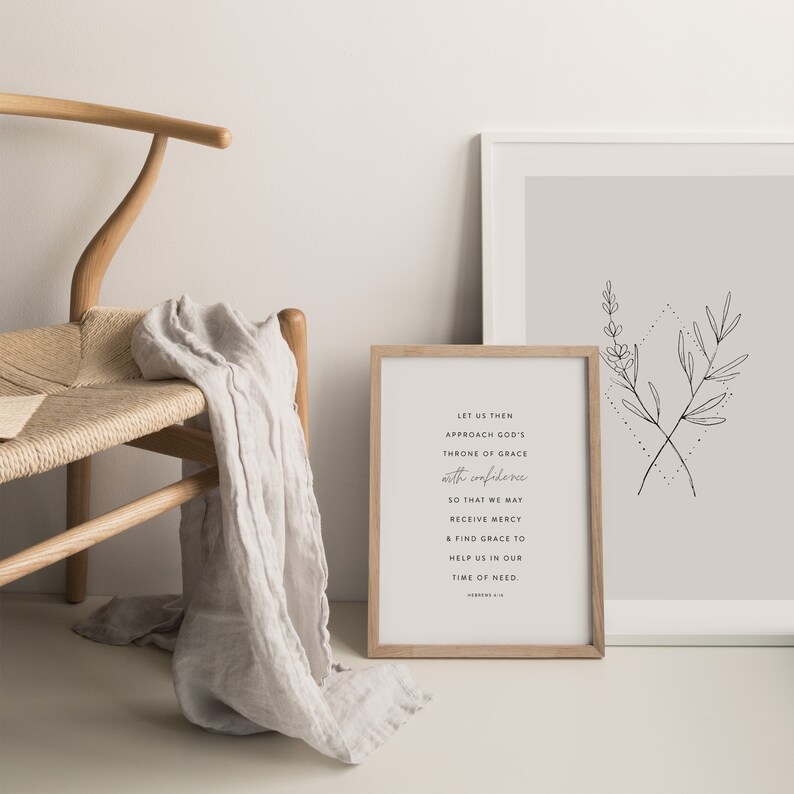 May include: A framed print with a beige background and a black and white illustration of two crossed branches with leaves. The text on the print reads: "Let us then approach God's throne of grace with confidence so that we may receive mercy & find grace to help us in our time of need. Hebrews 4:16"
