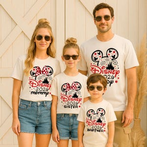 May include: Off-white t-shirts with a Disney 2026 design featuring Mickey Mouse ears, fireworks, and a castle. The shirts are labeled "mommy", "sister", "brother", and "pop". The family is wearing sunglasses and denim shorts.
