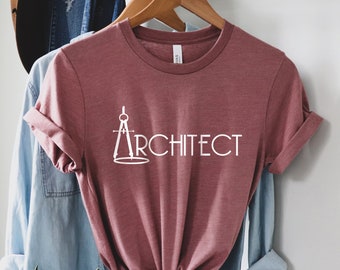 Può includere: Una maglietta color marsala con una bussola bianca e la scritta "ARCHITECT" stampata sul davanti.