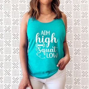 May include: A turquoise tank top with the text "AIM high squat low" in white lettering. The text includes a small dumbbell graphic.