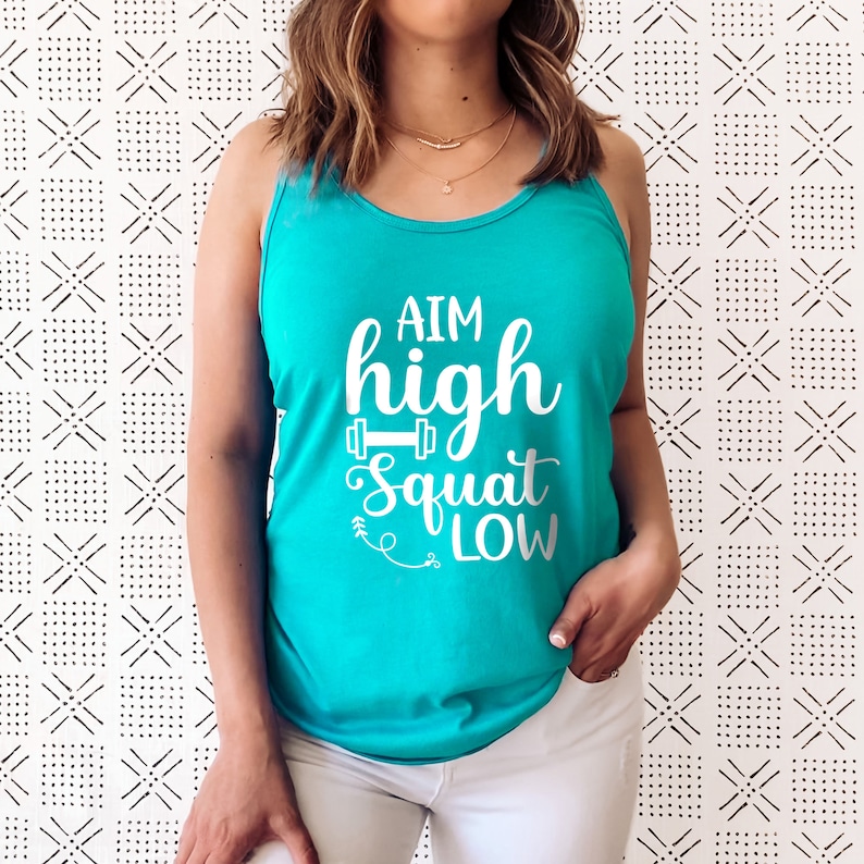 May include: A turquoise tank top with the text "AIM high squat low" in white lettering. The text includes a small dumbbell graphic.