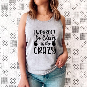 May include: Grey tank top with the text "I workout to burn off the crazy" in black lettering. The text includes a dumbbell graphic and two kettlebell graphics.