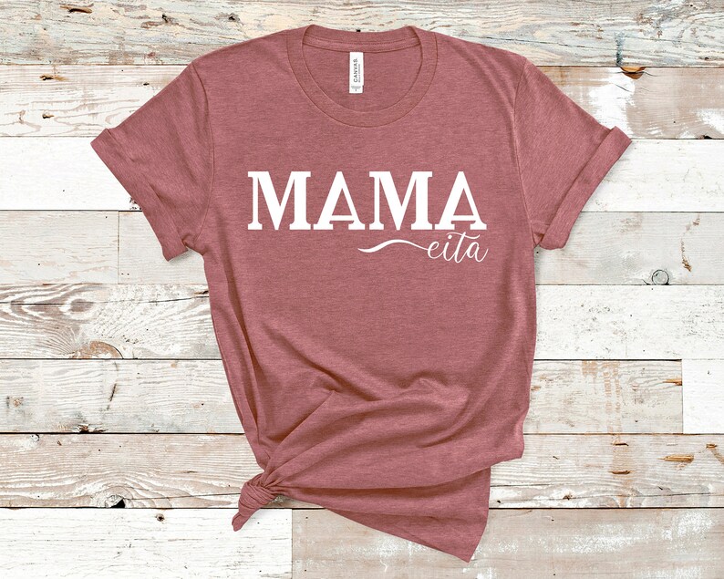 May include: A mauve t-shirt with the text "MAMA eita" printed in white.