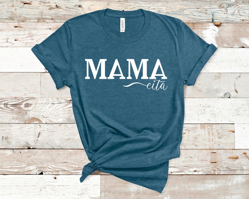 May include: A teal blue t-shirt with the text "MAMA eita" in white.