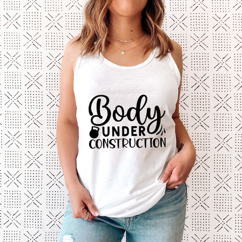 May include: White tank top with the text "Body Under Construction" and a black dumbbell icon.