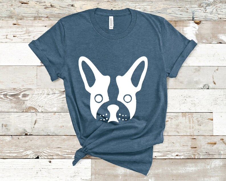 May include: A blue t-shirt with a white silhouette of a French bulldog's face.