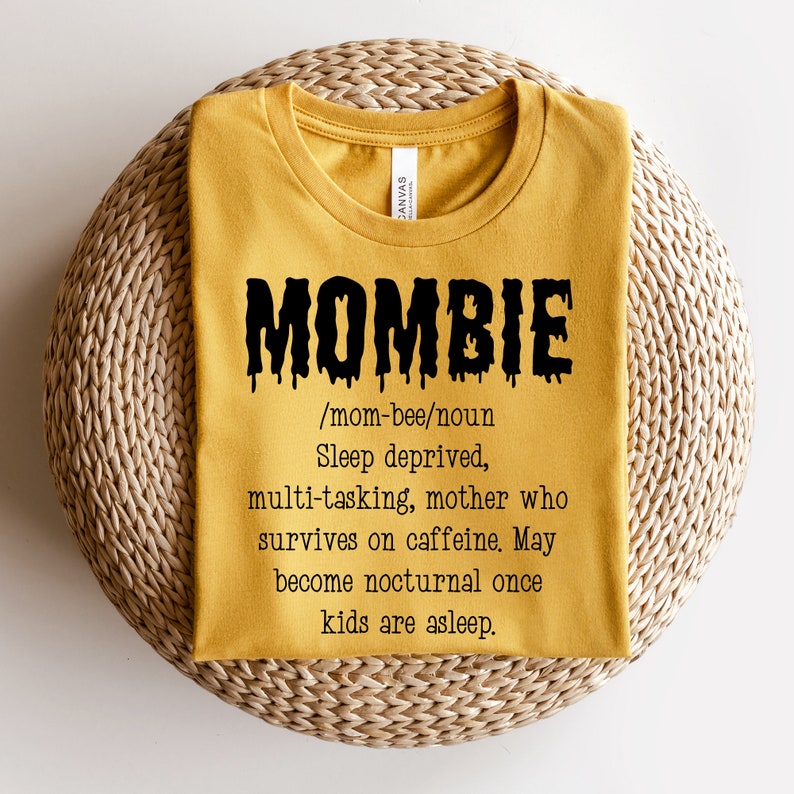 May include: A yellow t-shirt with a black graphic that says "MOMBIE /mom-bee/noun Sleep deprived, multi-tasking, mother who survives on caffeine. May become nocturnal once kids are asleep."
