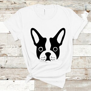 May include: White t-shirt with a black and white silhouette of a French bulldog's face.