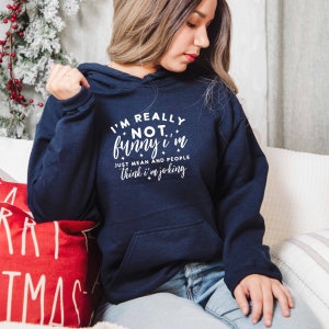May include: A navy blue hoodie with a white graphic that reads "I'm really not funny I'm just mean and people think I'm joking".