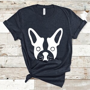 May include: A dark blue t-shirt with a white silhouette of a French bulldog's face.