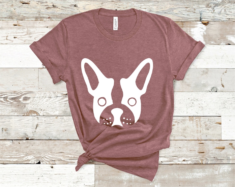 May include: A mauve t-shirt with a white silhouette of a French bulldog's face.