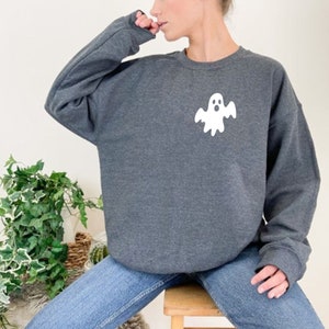 May include: A dark gray sweatshirt with a white ghost graphic on the front. The ghost has a surprised expression and is wearing a white sheet.