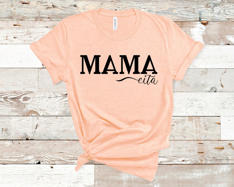 May include: A peach-colored t-shirt with the text "MAMA eita" printed in black.