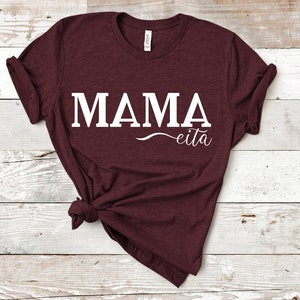 May include: A maroon t-shirt with the text "MAMA eita" printed in white.