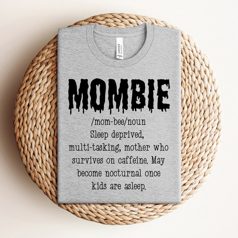 May include: A gray t-shirt with a black graphic that says "MOMBIE" and defines it as a "sleep deprived, multi-tasking mother who survives on caffeine. May become nocturnal once kids are asleep."