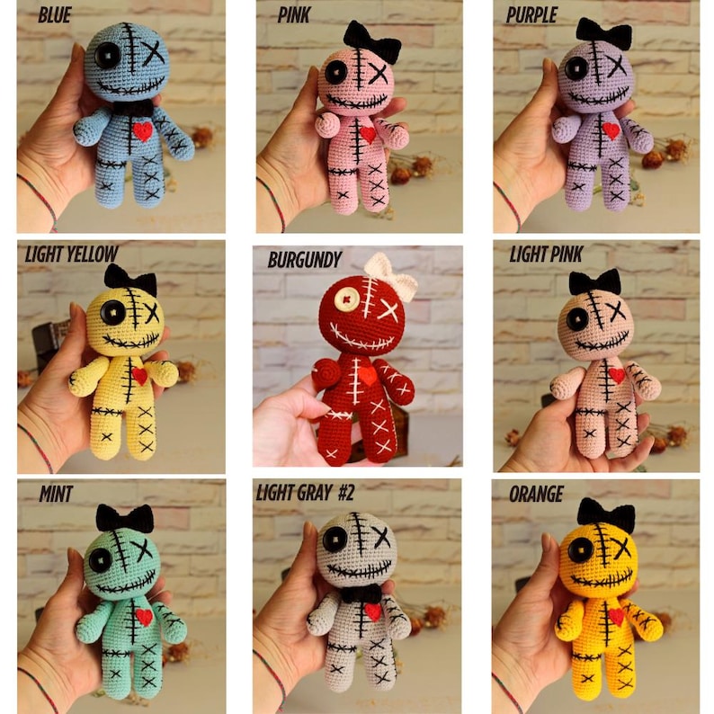 May include: A collection of nine crocheted dolls in various colors including blue, pink, purple, light yellow, burgundy, light pink, mint, light gray, and orange. Each doll features a button eye, an X-stitched eye, a stitched mouth, and a red heart.