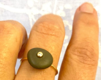 Santorini&#39;s gray pebble ring engraved with one diamond or gemstone in 18k yellow gold. Hand made ring with natural beach stone from Greece.