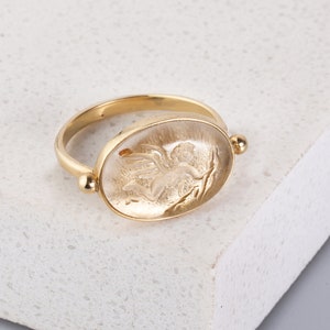Oval cristal de roche 14k solid gold ring with the angel of love carved design. Chic signet ring made in MELIGreece&#39;s workshop in Athens.