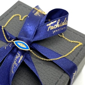 White diamonds with royal blue enamel eye-shaped pattern on a chain bracelet in 18k yellow gold. MELIGreece&#39;s jewelry gift for protection.