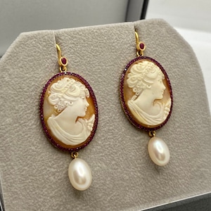 18k rose gold long amorous earrings with oval shell cameos, natural rubies & two fresh water pearls hanging. Anniversary jewellery present.