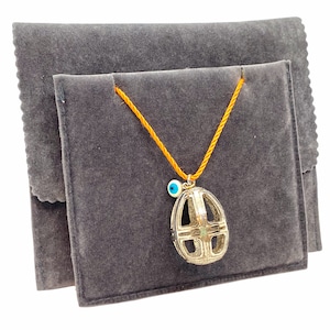 Perforated egg-shaped brass pendant white silver plated with an enamel eye, set in an orange cord. MELIGreece&#39;s Easter charm for fertility.