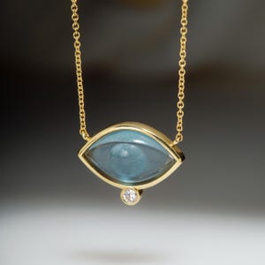 Carved blue topaz & diamond 18k yellow gold necklace set in a 18k yellow gold chain. November&#39;s birthday present speads strength, protection
