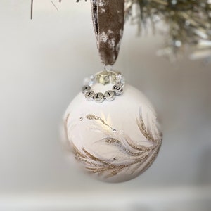 Könnte beinhalten: Weißer Weihnachtsbaumschmuck mit goldenen Glitzer und einem perlenbesetzten Namensschild mit der Aufschrift "Kylie".