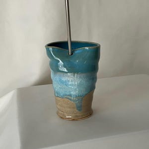 Copo de cerâmica artesanal feito à mão, azul claro sobre bege, comporta 13 oz