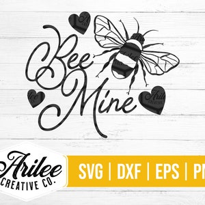 Peut inclure: Conception graphique en noir et blanc d'une abeille avec des ailes et un c&oelig;ur qui dit "Bee Mine". Le design est sur un fond de bois blanc. Le texte "Arilee Creative Co." est en bas de l'image. Le texte "SVG | DXF | EPS | PNG" est en bas de l'image.