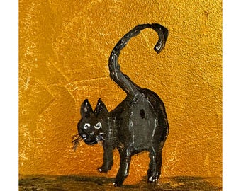 Op de afbeelding: Een zwarte kat met een gekrulde staart staat op een gouden achtergrond. De kat is in een eenvoudige stijl geschilderd met zwarte verf.